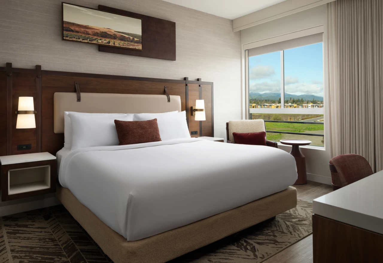 The Knoll Hotel King Bedroom with picture window, seating and desk.